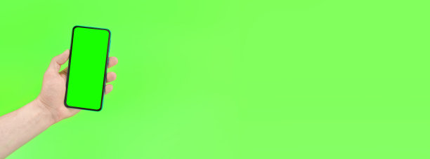 一个男人拿着一个绿色背景的绿色屏幕的智能手机。复制文本空间。横幅图片下载