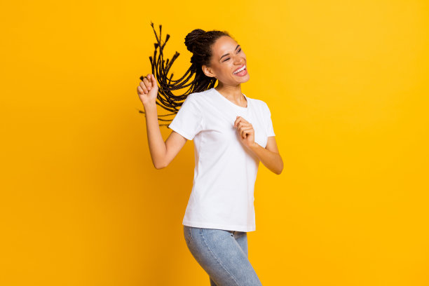 年轻的非洲女人的照片，快乐积极兴奋，无忧无虑，享受派对舞蹈，看空的空间孤立在黄色的背景图片下载