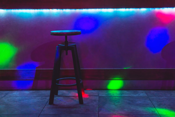 酒吧里的椅子概念。彩色霓虹灯。黑暗的抽象背景。图片下载