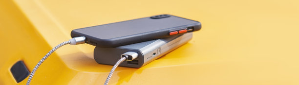 Powerbank在背景旅游冰箱上为智能手机充电。关于旅游和旅游主题的概念。图片下载