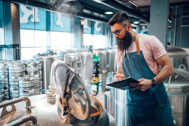 在啤酒厂工作并记录啤酒生产的人图片下载
