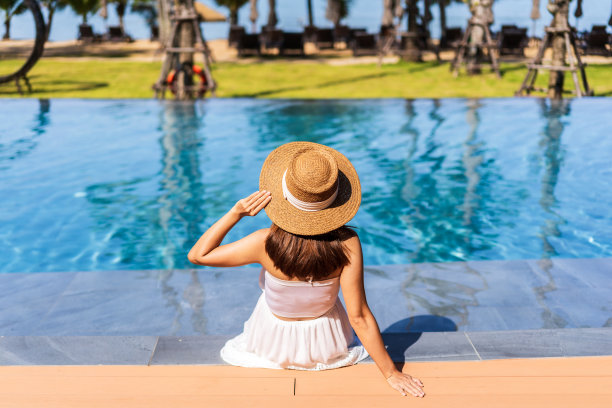 年轻的女性旅行者放松和享受热带度假池，而旅行的暑假图片下载