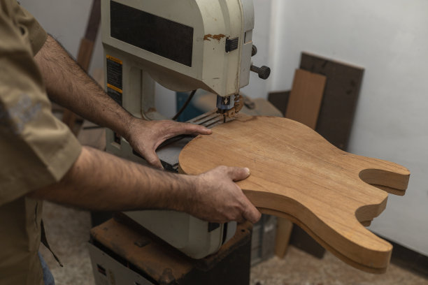 无法辨认的拉丁美洲制琴师用锯子制作电吉他的特写。弦乐器结构概念图片下载