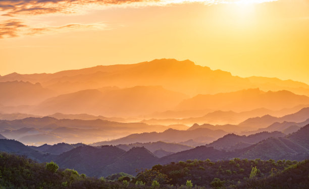 一层层的山沐浴在黄色的晨光中素材图片