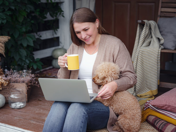 带着笔记本电脑在花园户外工作的女人，家庭办公室的概念。图片下载