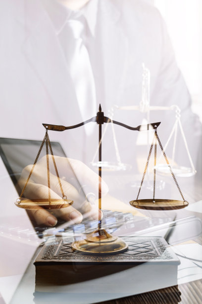 律师事务所图书馆书桌上摆放着法律书籍和司法天平。法学、法学教育理念。图片下载