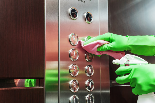 用消毒液和餐巾纸消毒电梯。图片下载