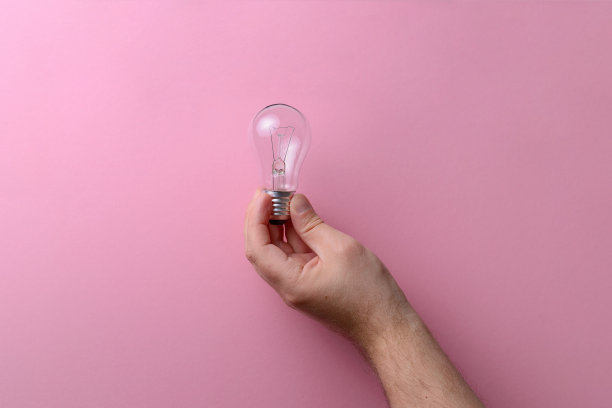灯在男人手里作为光的象征，粉红色的背景。图片下载