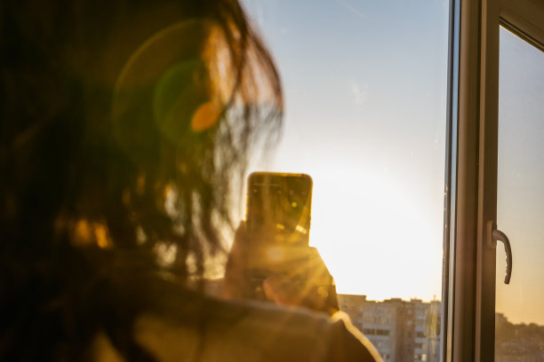 不明身份的女人在拍日落照片图片下载