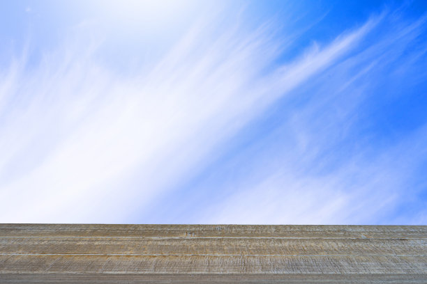 抽象旧木桌对流动的云天空背景。图片下载