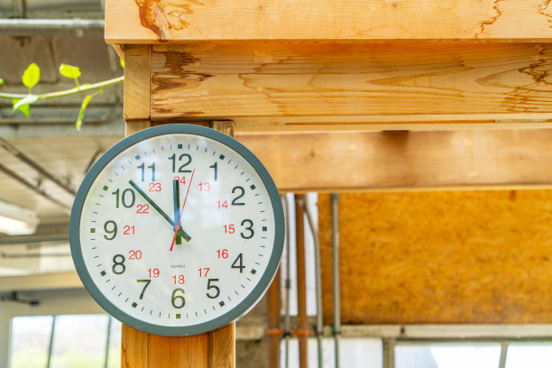 挂在木制架子上的挂钟指向中午12点图片下载