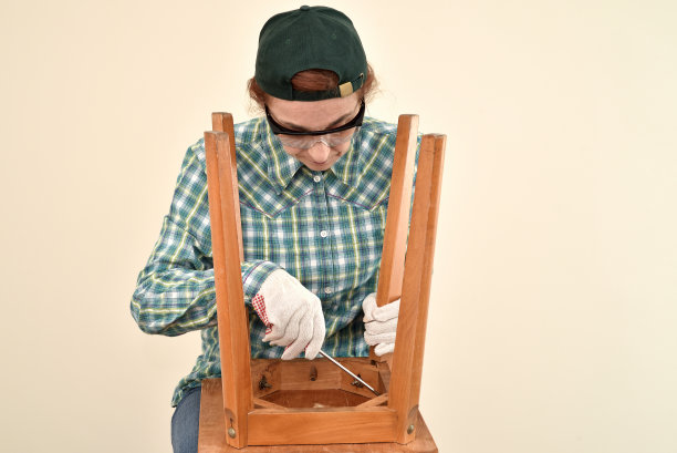 一位正在修理旧椅子的中年妇女图片下载
