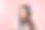 美丽的年轻女子在无线耳机听音乐在粉红色的背景。女孩使用无线耳机图片下载