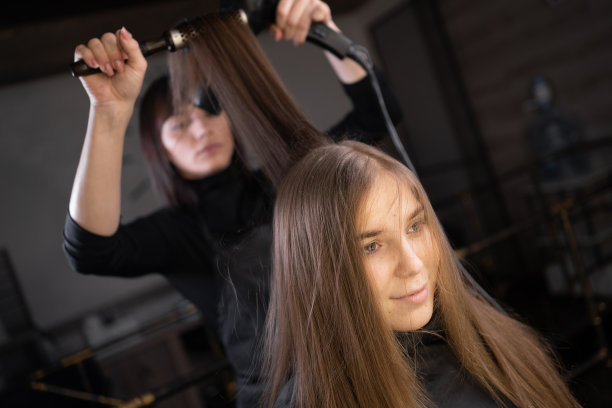 吹风机。美容院女造型师。洗完头发后把头发弄干。一个女人和一个女孩一起做头部护理图片下载