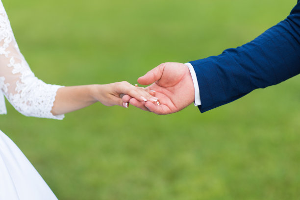 新郎触摸新娘的手，特写图片下载