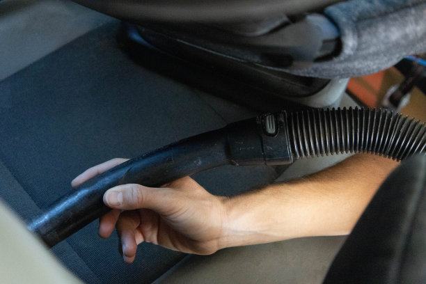 白人男性用吸尘器清洗汽车。图片下载