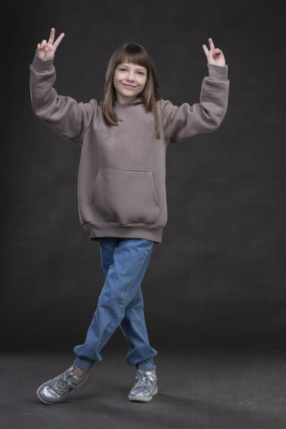 美丽的十岁时装模特女孩在灰色的背景下充分成长。图片下载