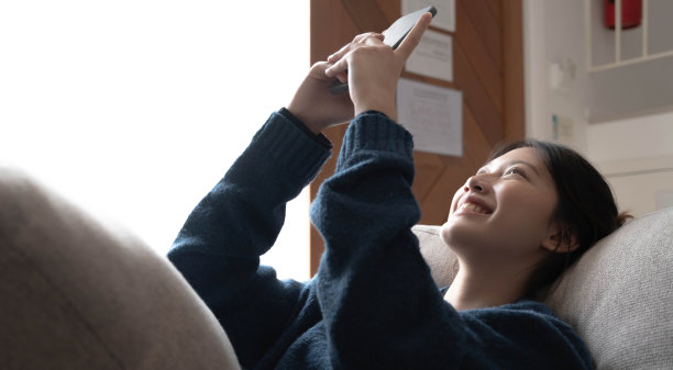 微笑的肖像快乐开朗的美丽漂亮的亚洲女人放松的自拍照片在网络相机。躺在舒适的沙发上。图片下载