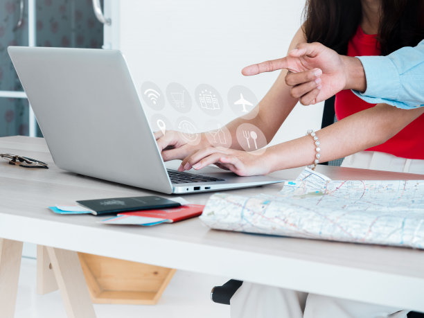 旅行计划概念：笔记本电脑上的旅行信息图标、机票预订、酒店、餐厅、餐饮、无线网络、货币兑换、购物场所，以及护照和地图图片下载