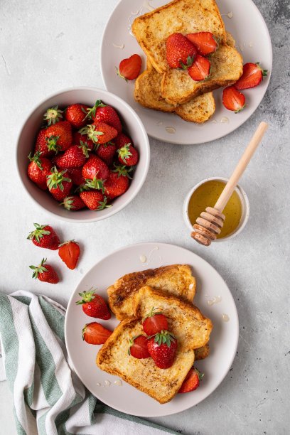 传统的法式吐司，灰色底色配上草莓和蜂蜜。夏季早餐，早午餐或午餐浆果。前视图。图片下载