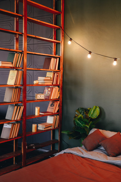 一张床的垂直照片与棕色格纹，阁楼花环和绿色的花。休息的地方。图片下载