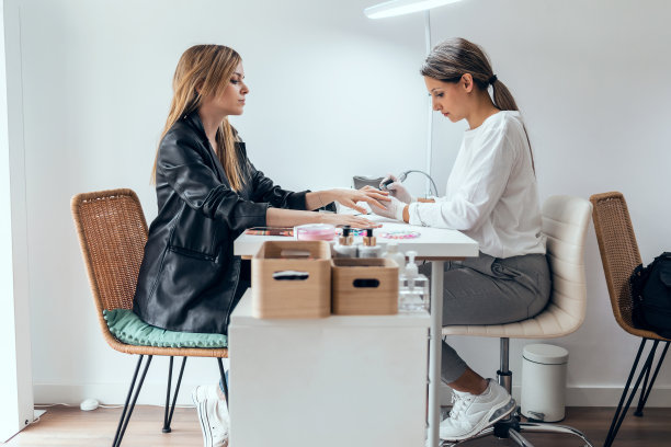 年轻漂亮的女人在美容院做永久美甲。美丽的概念。图片下载