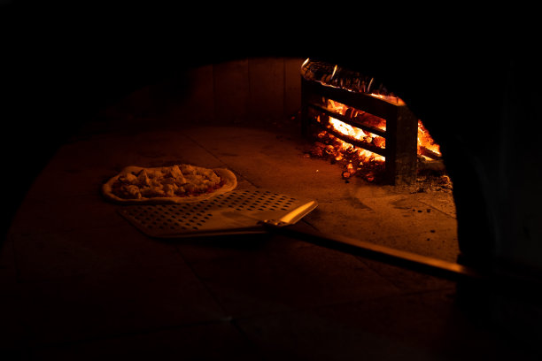 用铲子把披萨放进烤箱图片下载