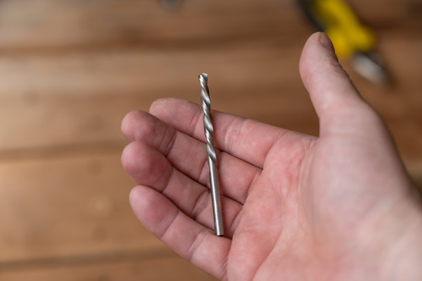 银钻在人的手中。钻头是一种用于在各种材料上钻孔的切削工具。第一人称的观点。有选择性的重点。图片下载