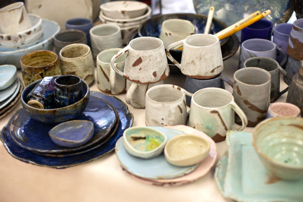 各种各样的盘子，碗，玻璃杯和茶托的粘土。侘寂风格的生态陶瓷手工菜。粘土手工制作的盘子和陶瓷杯子。收藏工艺釉餐具。生态系统概念图片下载
