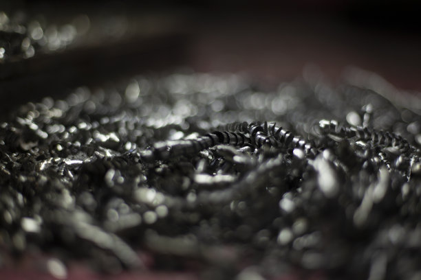 金属碎屑。生产浪费。钻孔后的钢屑。垃圾在车间。图片下载