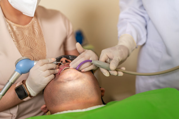 牙医和助手为病人清洁牙齿图片下载