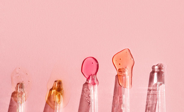 带液体透明质酸的移液器放在阳光下的粉红色背景上。化妆品和保健概念特写图片下载