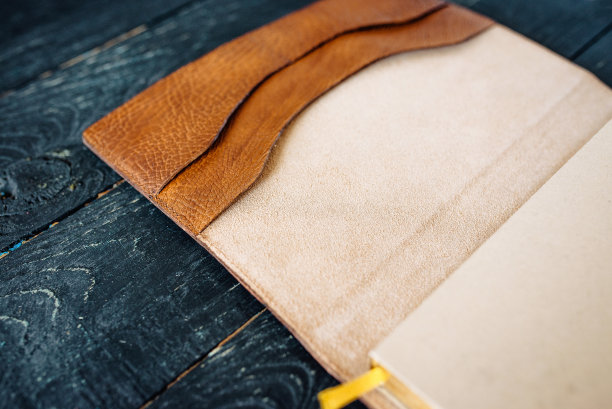 皮革手工笔记本(组织者)在黑暗的木制背景图片下载