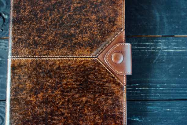 皮革手工笔记本(组织者)在黑暗的木制背景图片下载