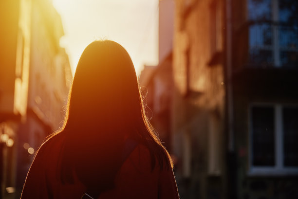 女人的背影走在城市街道与日落图片下载