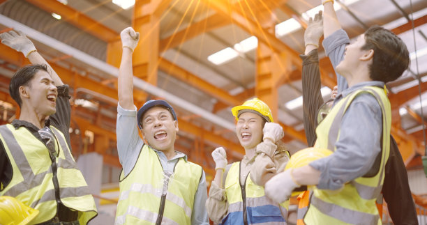 团队合作的象征。快乐的领导，在制造业的员工叠起双手表示团结，庆祝成功的好结果的工作。在工厂里，一群群掌握各种技能的工人在一起握手。图片下载