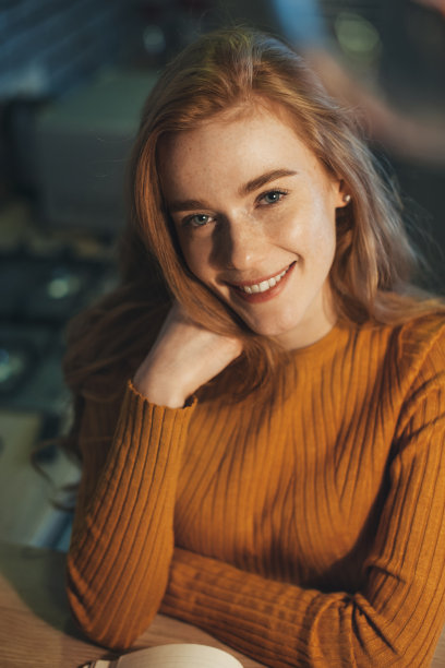 快乐的雀斑女子居家学习，写字，微笑。女商人肖像。现代生活方式。图片下载