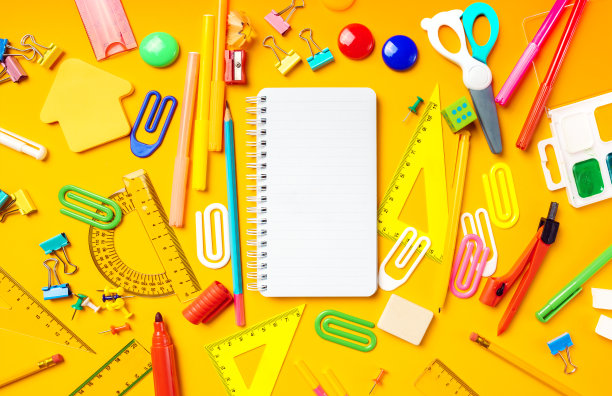 回到学校的平面躺着一个复印空间。黄色背景的空的记事本和学校用品。前视图。图片下载