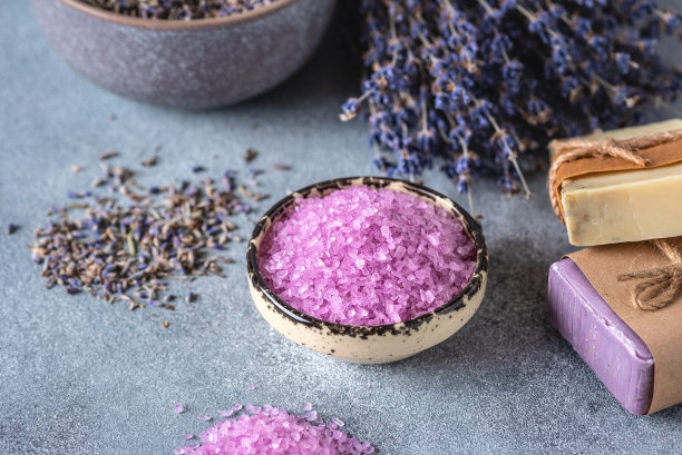薰衣草海盐和薰衣草皂。水疗产品。灰色的背景。侧视图，选择性聚焦。图片下载
