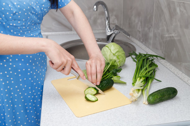 一个女人在厨房准备蔬菜沙拉的特写图片下载
