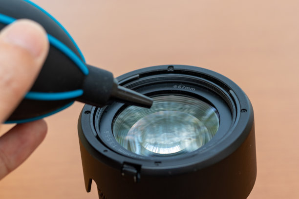 用鼓风机吹掉相机镜头表面的灰尘图片下载