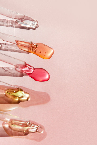 带液体透明质酸的移液器放在阳光下的粉红色背景上。化妆品和保健概念特写图片下载