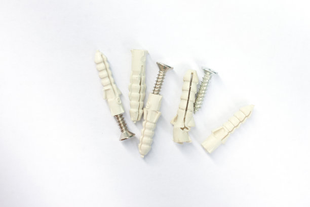 白色背景上带金属螺钉的塑料锚栓俯视图图片下载