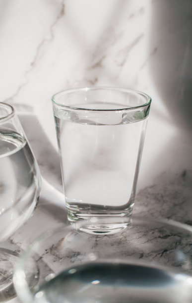 阳光透过水玻璃，在白色背景上通过光的折射，形成美丽的光影图案。图片下载