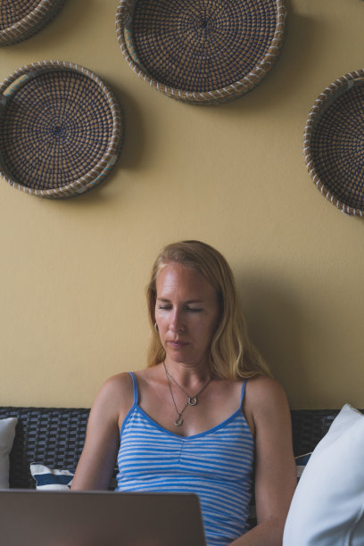 专注的女人在笔记本电脑上工作，穿着休闲的衣服，自由的坐着图片下载