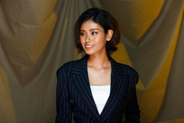 半身20多岁的亚洲印度女人晒黑的皮肤穿正式的西装连衣裙卷发美容皮肤图片下载