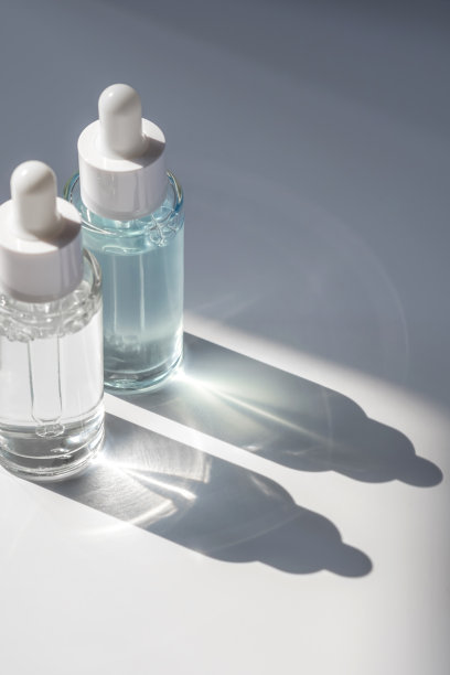 两瓶简洁的化妆液在刺眼的阳光下。图片下载