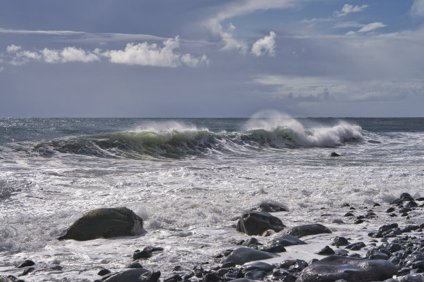 碧绿的海浪在银色的云中拍打着海滩图片下载