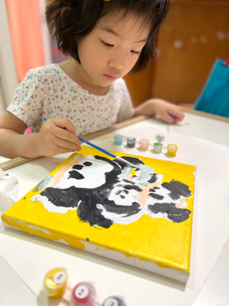 可爱的小女孩在她的画上画画图片下载