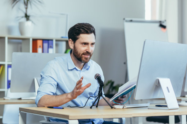 成功快乐的商务教练导师，录制音频播客，使用专业麦克风，商人在现代白色办公室，进行在线商务培训图片下载